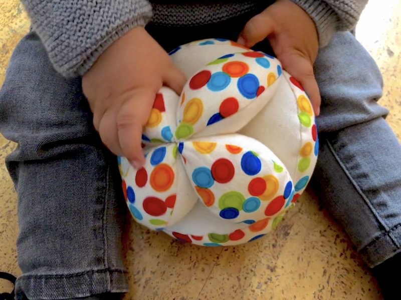 Bebé jugando con la pelota montessori