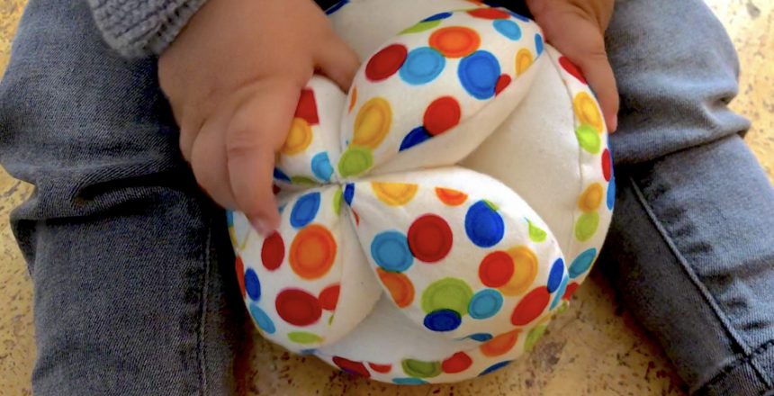 Bebé jugando con la pelota montessori